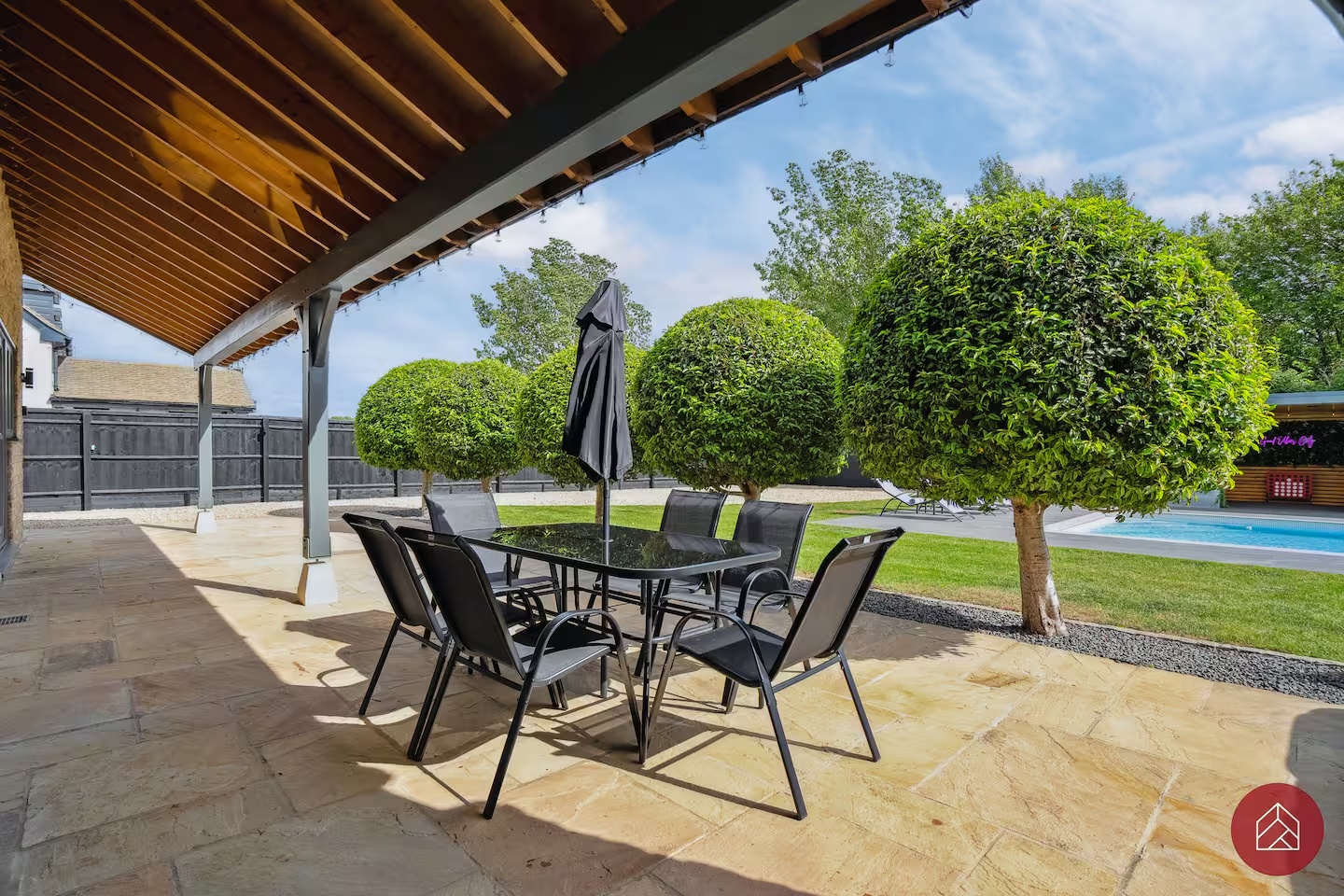 Covered outdoor dining terrace beside the garden and pool